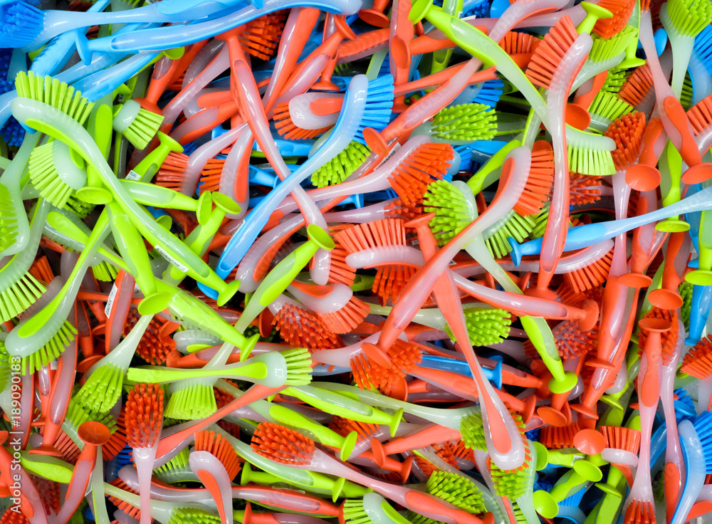 hundreds of colourful plastic dishwasher brushes stacked up, red blue and green colours