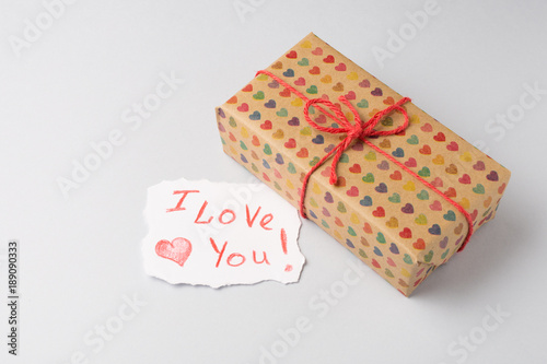 Gift box with heart design prints and I love paper card on light gray background. Saint Valentine's Day concept.
