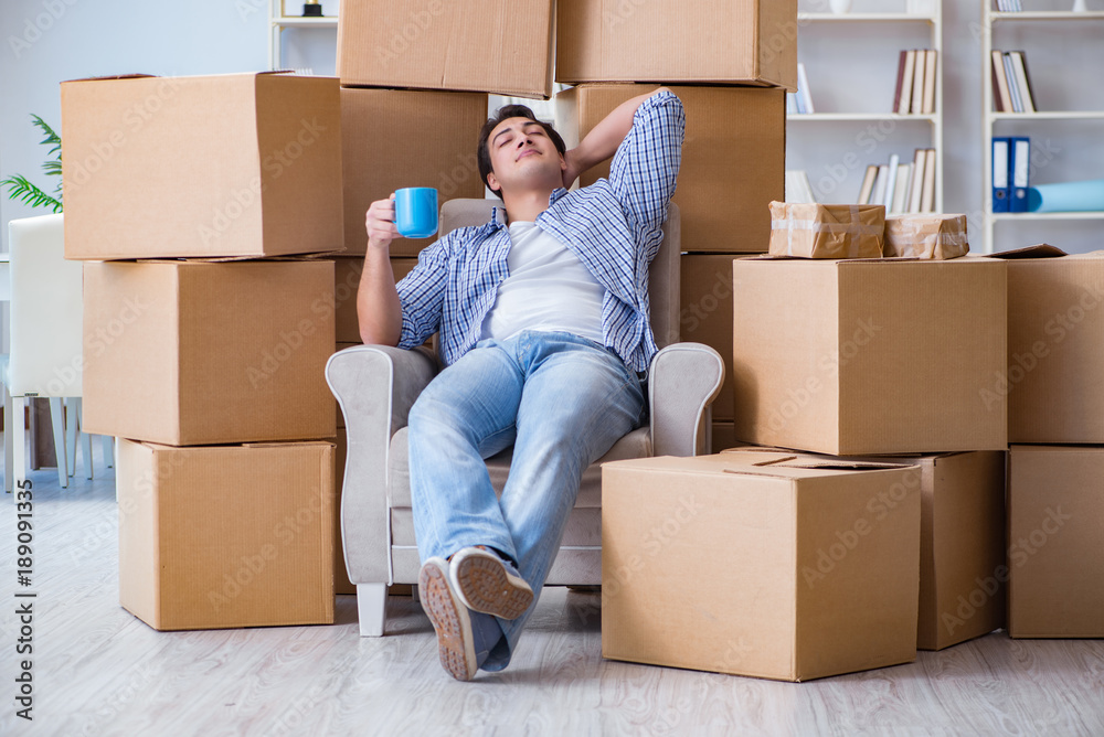 Young man moving in to new house with boxes Young man moving in to new house with boxes
