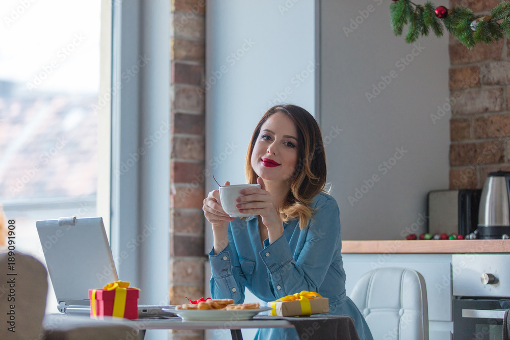 Portrait of redhead woman with cup of coffee or tea at kitchen