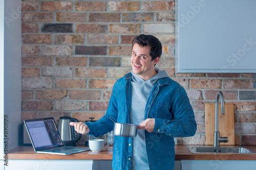 Young handsome man cooking at kitchen photo