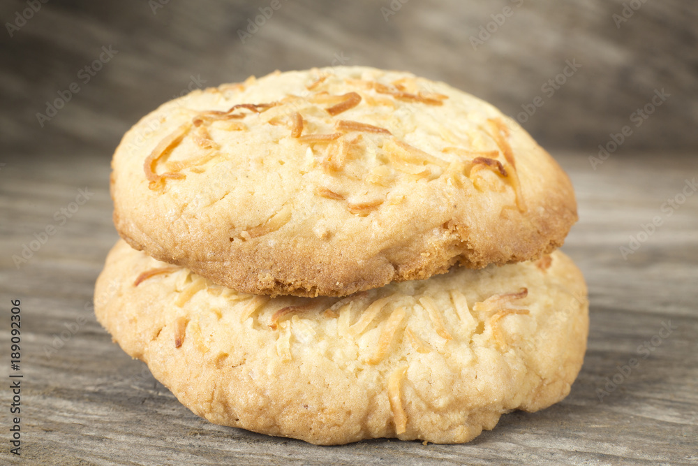 Two coconut cookies on the wooden background