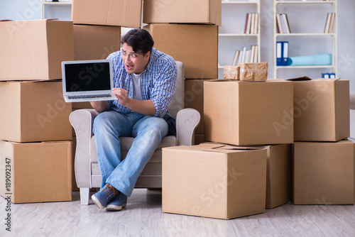 Young man moving in to new house with boxes