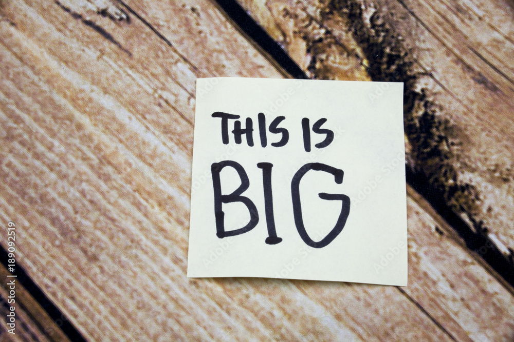 Sticky note on the wooden background and text concept, this is big meaning big event, surprise Sticky note on the wooden background and text concept, this is big meaning big event, surprise