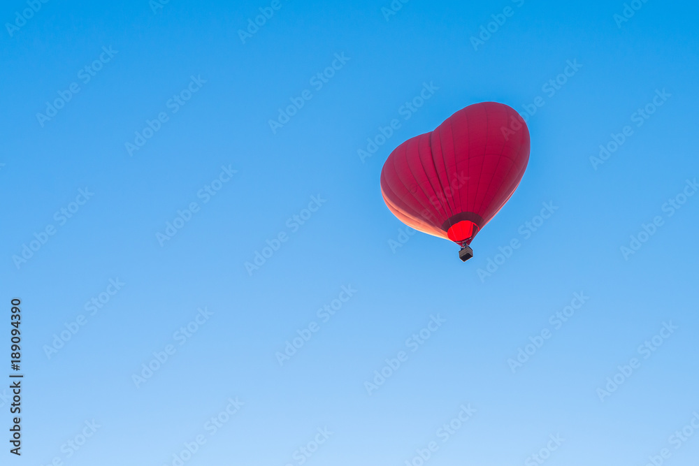 Red air in the form of a heart balloon in the blue sky Red air in the form of a heart balloon in the blue sky