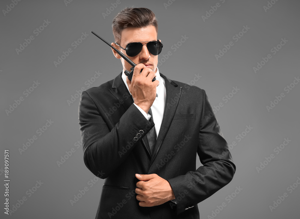 Handsome security guard on grey background Handsome security guard on grey background