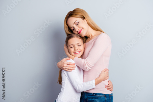Portrait of beautiful charming delicate warm close sweet nice touching adorable cheerful friendly kind peaceful calm loving mum and obedient excited kid, casual clothes, isolated on gray background