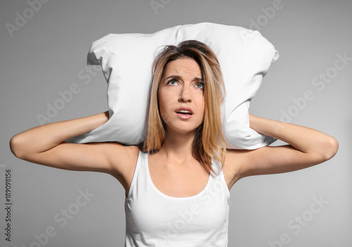Young woman covering her ea...