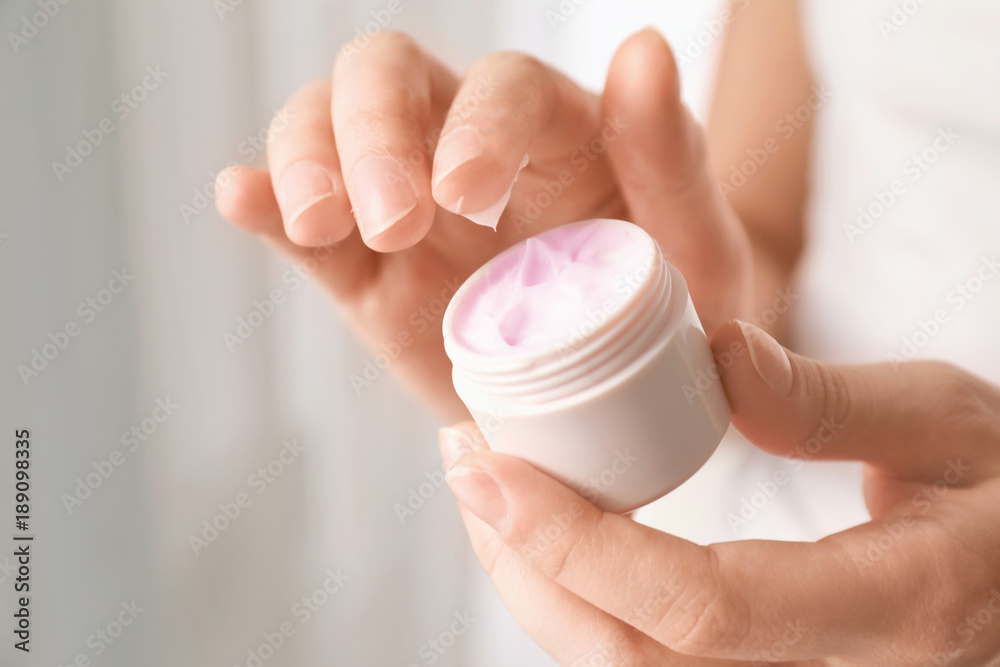 Young woman holding jar of hand cream, closeup Young woman holding jar of hand cream, closeup