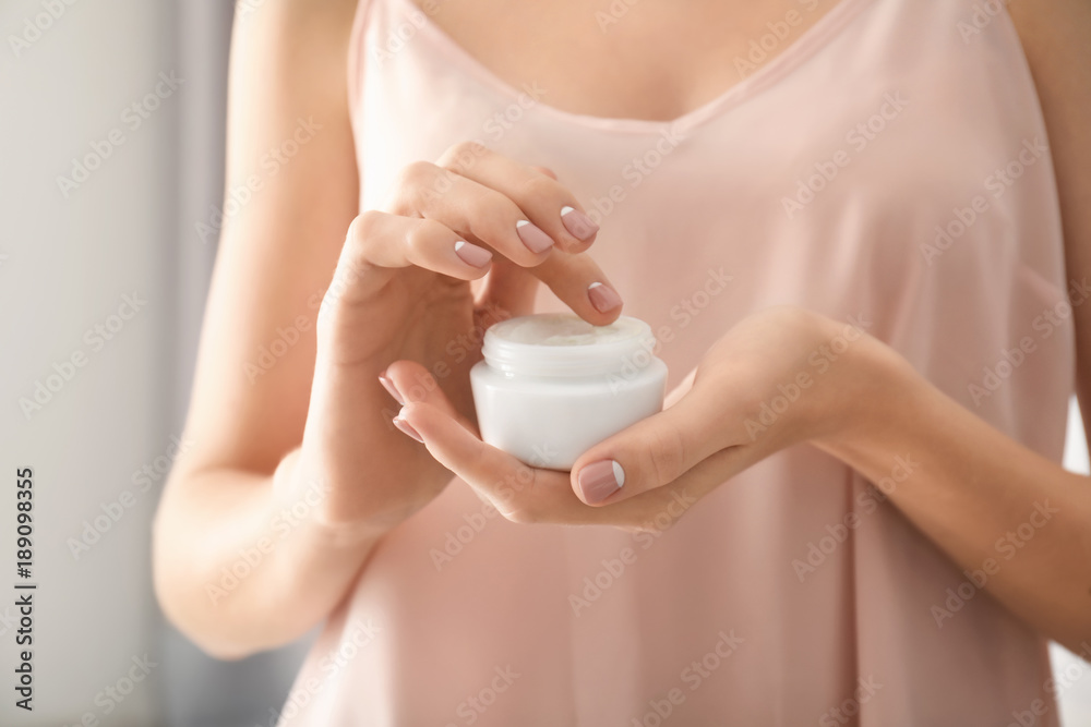 Young woman holding jar of hand cream, closeup Young woman holding jar of hand cream, closeup