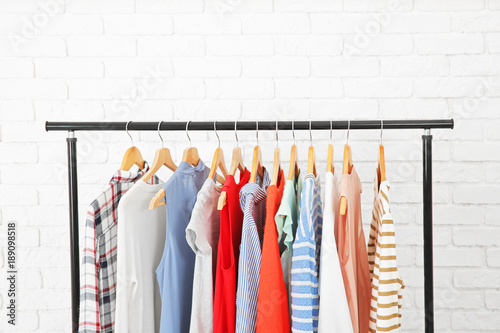 Rack with collection of clothes in dressing room photo
