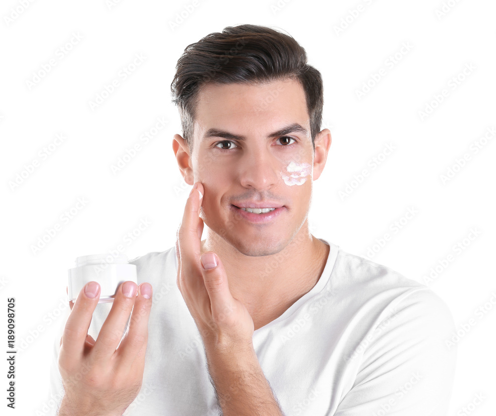 Handsome man applying face cream on white background Handsome man applying face cream on white background