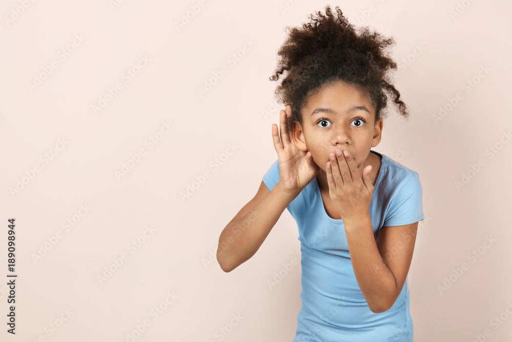 Little African-American girl with hearing problem on light background Little African-American girl with hearing problem on light background