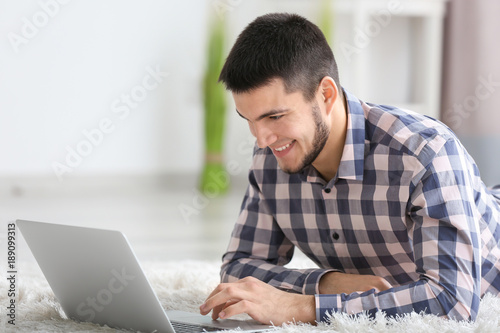 Young man using modern lapt...