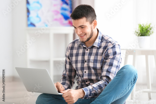 Young man using modern lapt...