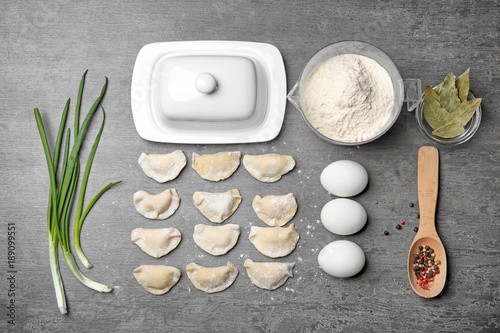 Raw dumplings and ingredients on table, top view