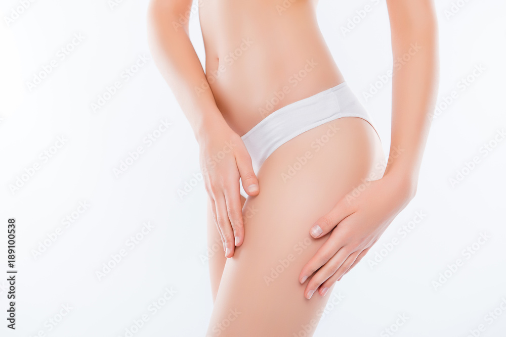 Wellness wellbeing purity freshness concept. Cropped close up photo of skinny slim slender attractive fit woman's thighs wearing white underpants gently touching soft fresh skin isolated on background
