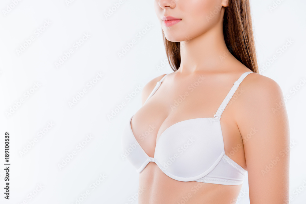 Cropped half-turned closeup photo of healthy big stunning seductive woman's  breast dressed in white bra flawless soft elegant gentle nice skin skinny  arms isolated on background copyspace Stock Photo
