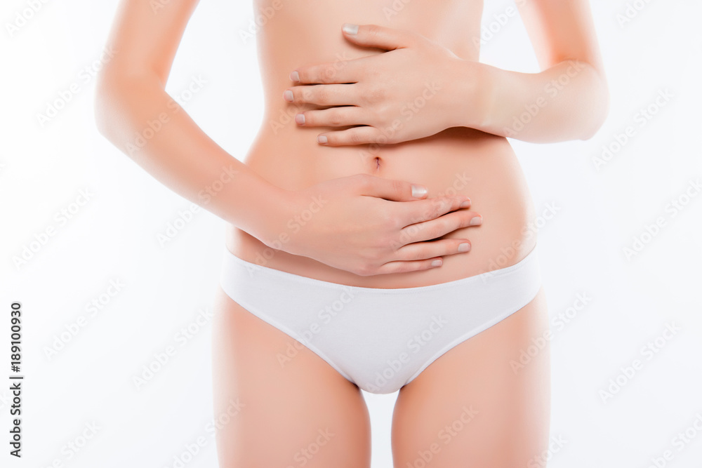 Early terms of pregnancy concept. Cropped close up photo of slim sexy beautiful skinny woman hugging touching her tummy, wearing white classic underclothes isolated on white background
