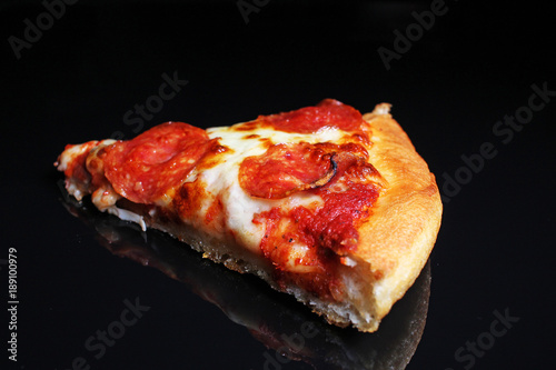 Pizza. Pizza slice on black reflective studio background. Isolated black shin...
