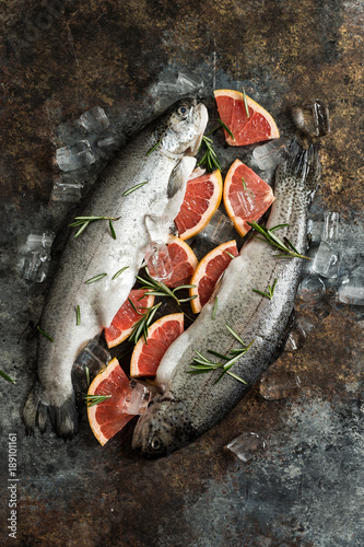 Overhead view of trout fish with grapefruit on wooden background photo