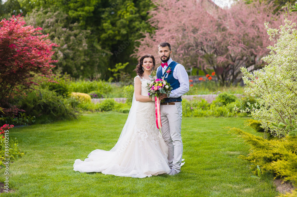 Bride and groom posing in beautiful garden