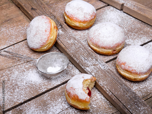 Traditional Polish donuts on wooden powder. Tasty doughnuts with jam.