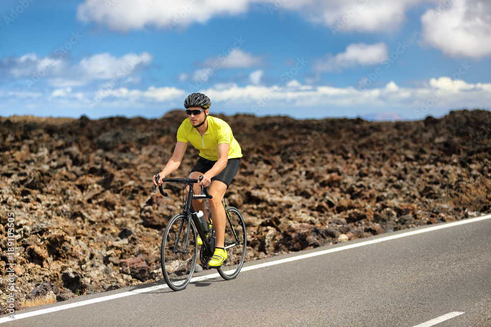 Fototapeta premium Triathlon biking cyclist man athlete on road bike. Fitness workout outdoors in nature landscape. Male sports competition.