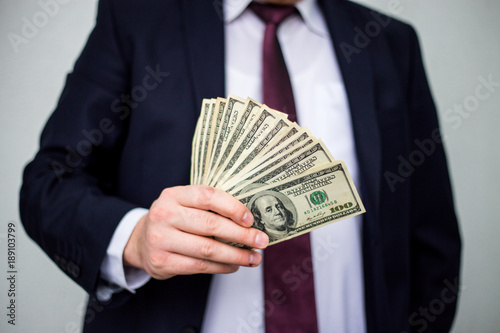 Business Man Displaying a Spread of Cash over a white vintage background