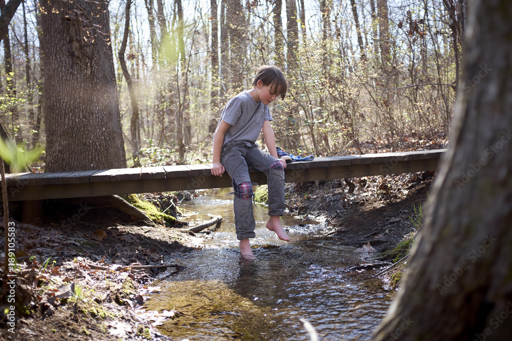Boy Sitting on Bridge Over Creek Boy Sitting on Bridge Over Creek
