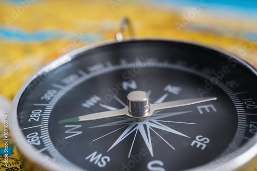 Close up view on compass and map in background.