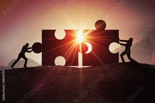 Teamwork, partnership and cooperation concept. Silhouettes of two businessman joining two pieces of puzzle together.