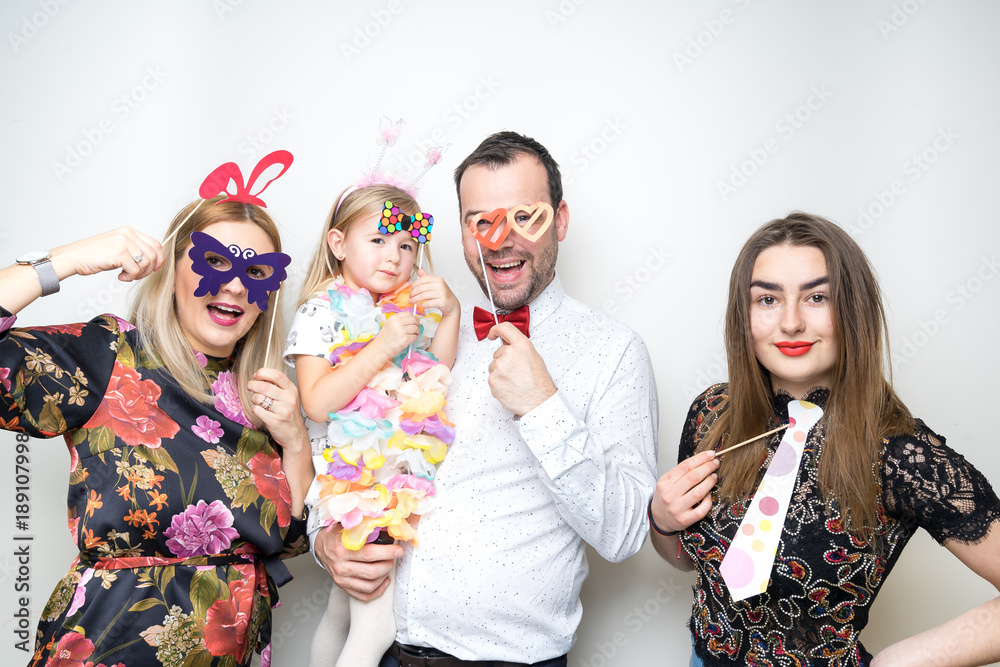young family posing party photo booth props baby girl plain background studio