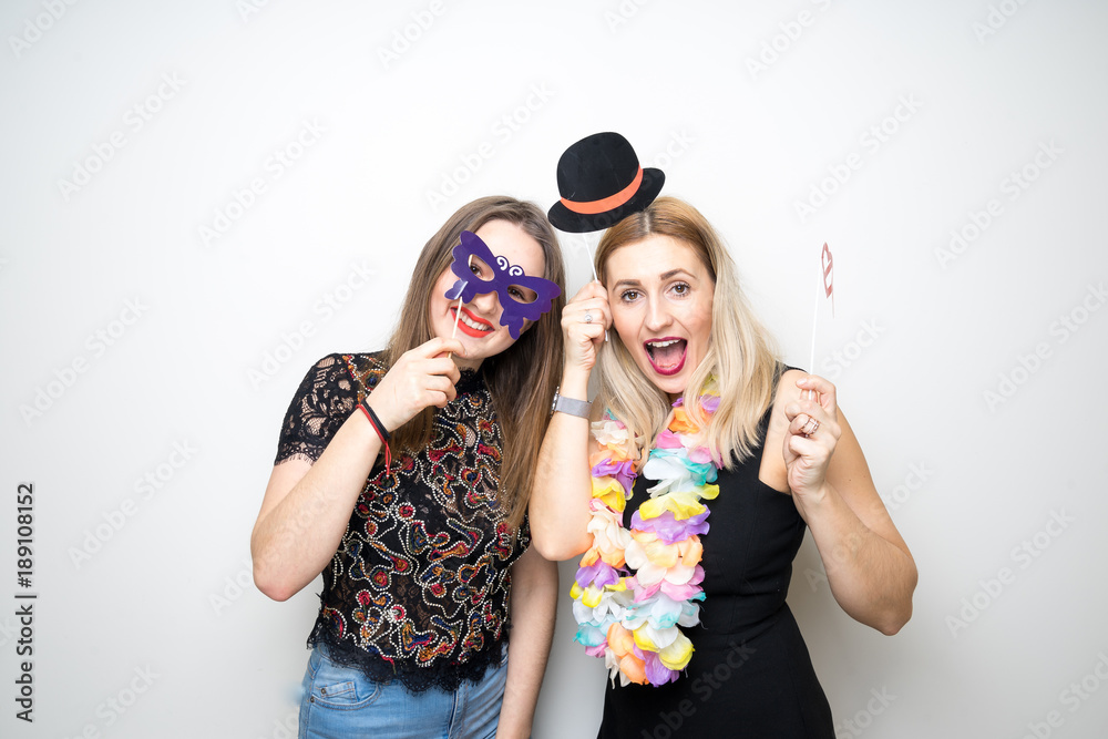 two girls posing party props photo booth white background studio drunk happy laugh