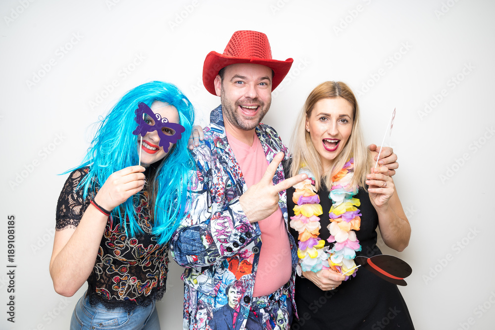 three people girls man posing party props photo booth white plain background studio hat