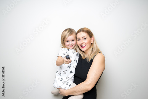 Obraz na płótnie young mom and daugter baby girl posing photo booth remote control camera plain background studio w salonie