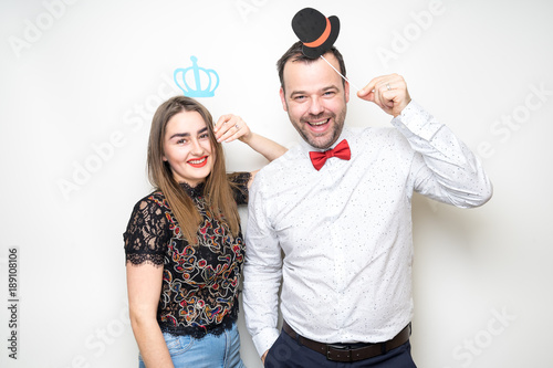 young couple posing wedding photo booth props happy smile plain background