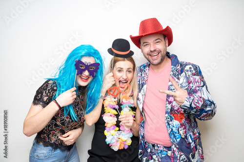 three people girls man posing party props photo booth white plain background studio hat