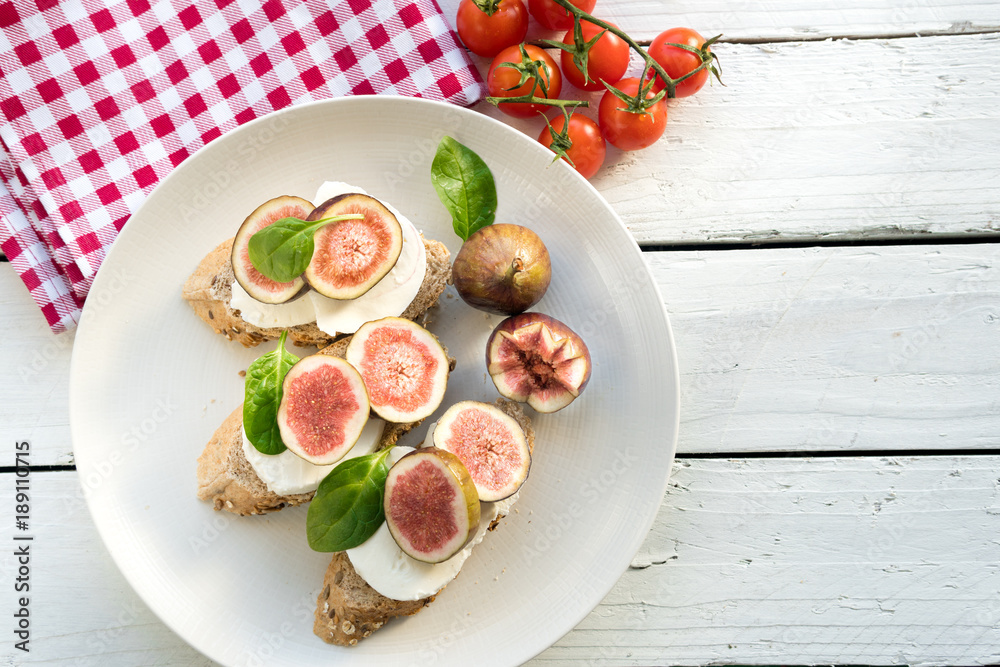 fresh ripe sliced fig on toast bread mozzarella cheese Italian crostini dish light lunch starter
