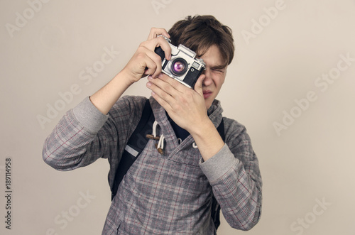 Teenager holding analog camera and taking picture 