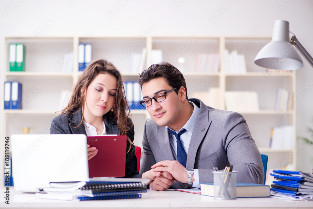 Obraz premium Happy couple working in the same office