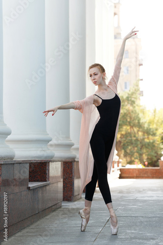 Ballerina in pointe dancing in street. © Vagengeim