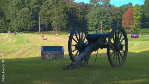 Cold Harbor National American Civil War Battlefield featuring a Confederate Field Artillery Cannon in the foreground and People Visiting the Historical Site in the background photo