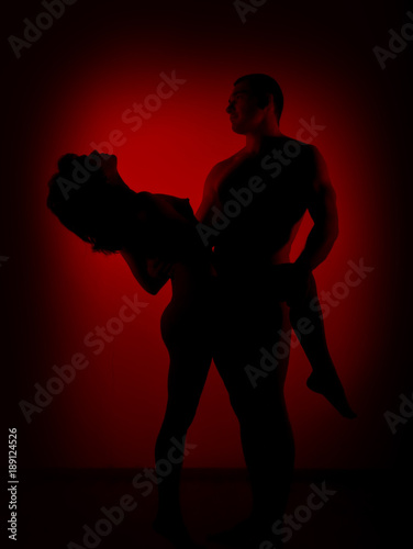 silhouette of couple woman man dancing in studio on red background