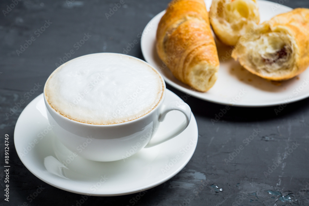 Cup of coffee with croissants on the rustic wooden background. Selective focus. Shallow depth of field. Cup of coffee with croissants on the rustic wooden background. Selective focus. Shallow depth of field.