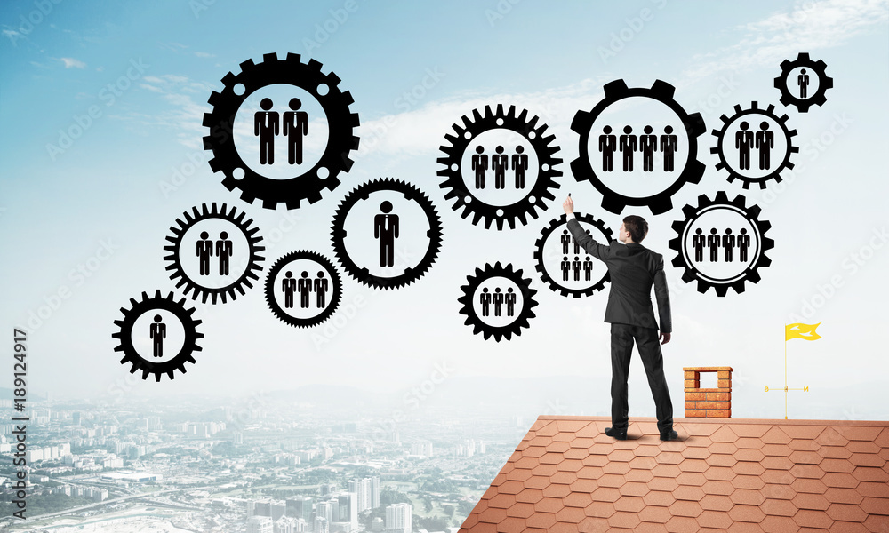 Businessman on house roof presenting teamwork and connection concept. Mixed media