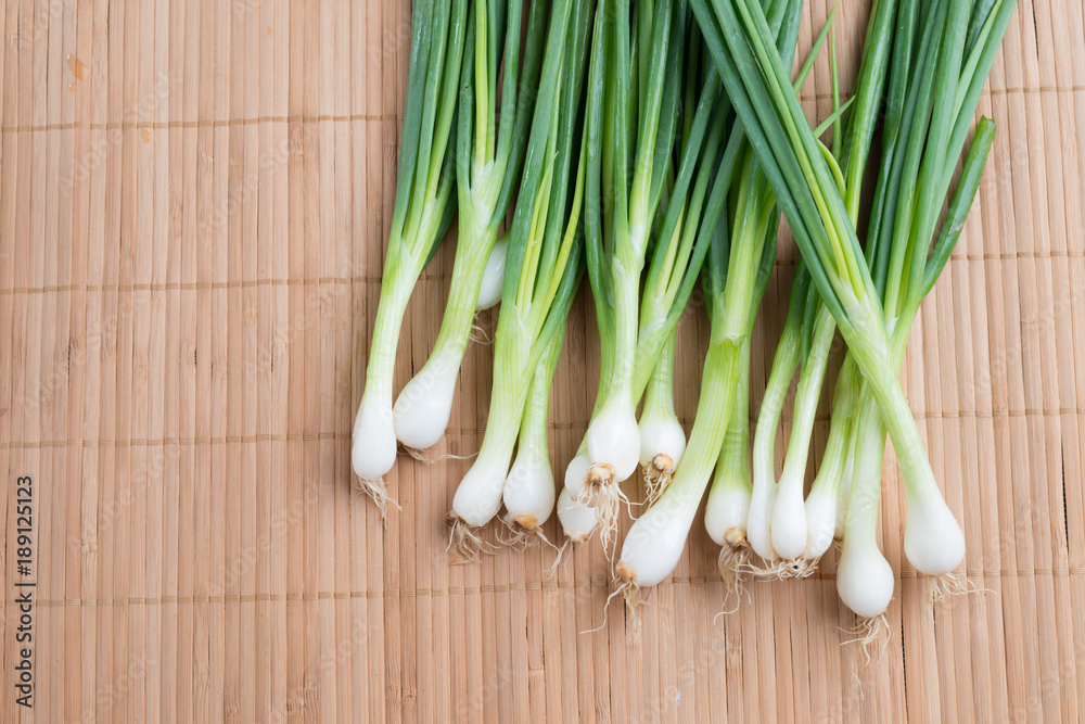 Pile of fresh spring onion on wood table Pile of fresh spring onion on wood table
