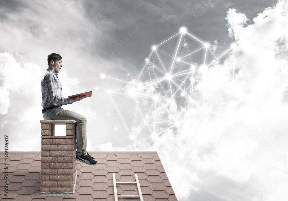 Man on brick roof reading book and concept of social connection Man on brick roof reading book and concept of social connection