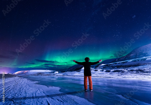 The polar arctic Northern lights aurora borealis sky star in Norway Svalbard in Longyearbyen city town mountains