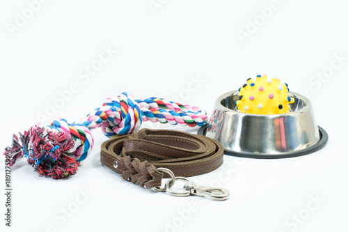 Pet supplies set about stainless bowl, rope, rubber toys and leather of leash for dog or cat on white background